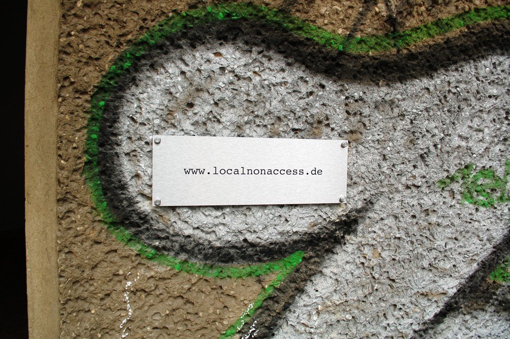 local.#non.access — the plaque 'www.localnonaccess.de' on the graffiti-sprayed facade