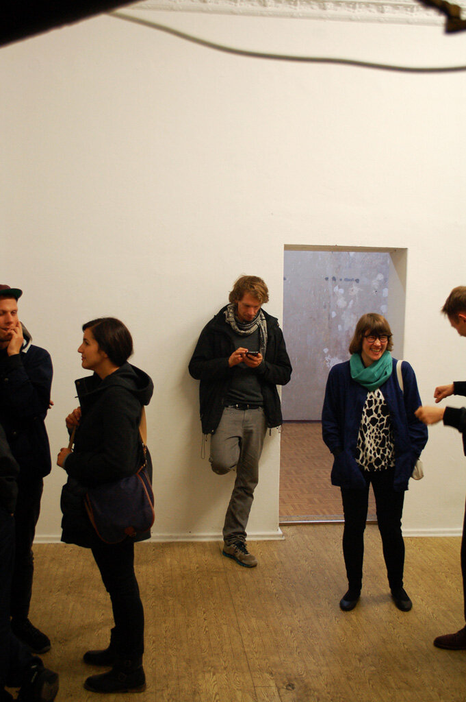 local.#non.access opening — visitors talking and browsing the show on their phones