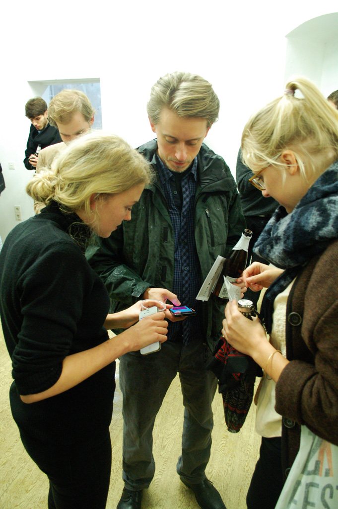 local.#non.access — opening-night visitors gathered around a phone
