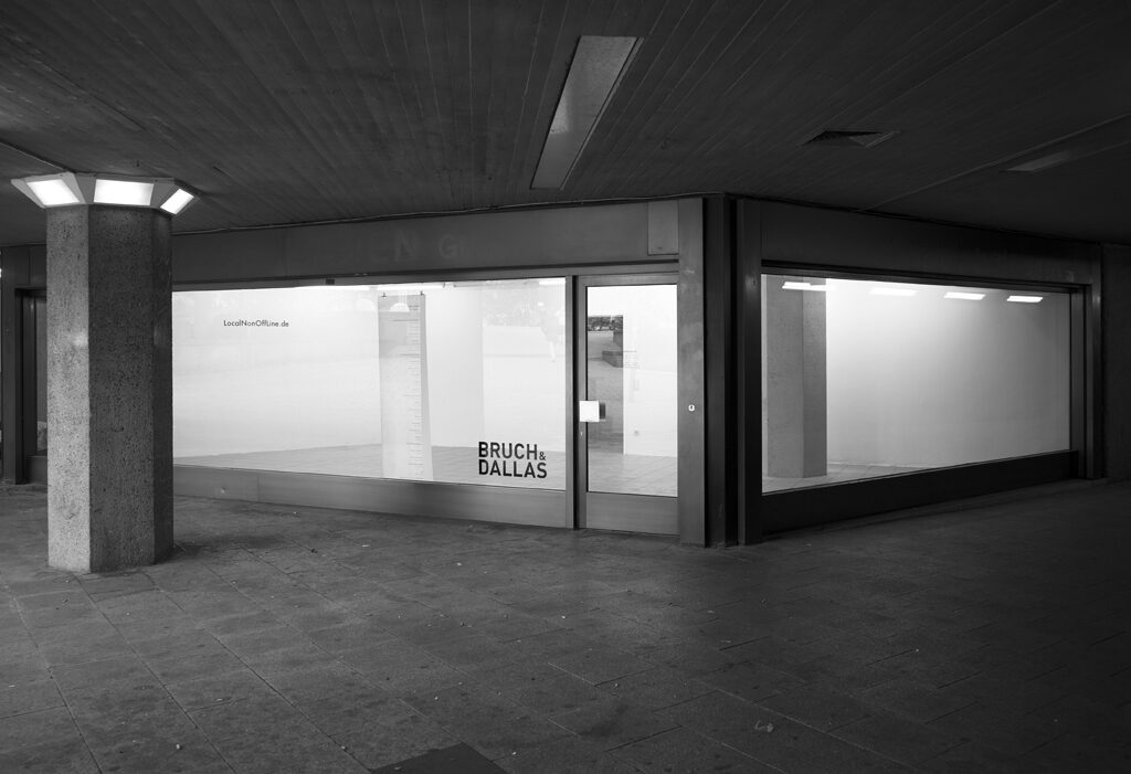LocalNonOffline — black-and-white: the empty Bruch & Dallas storefront with the LocalNonOffLine.de lettering