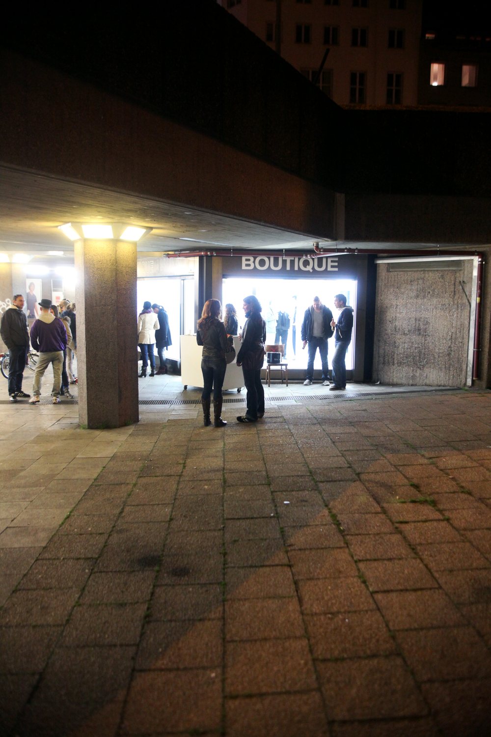 LocalNonOffline — the opening crowd in front of the illuminated shopfront