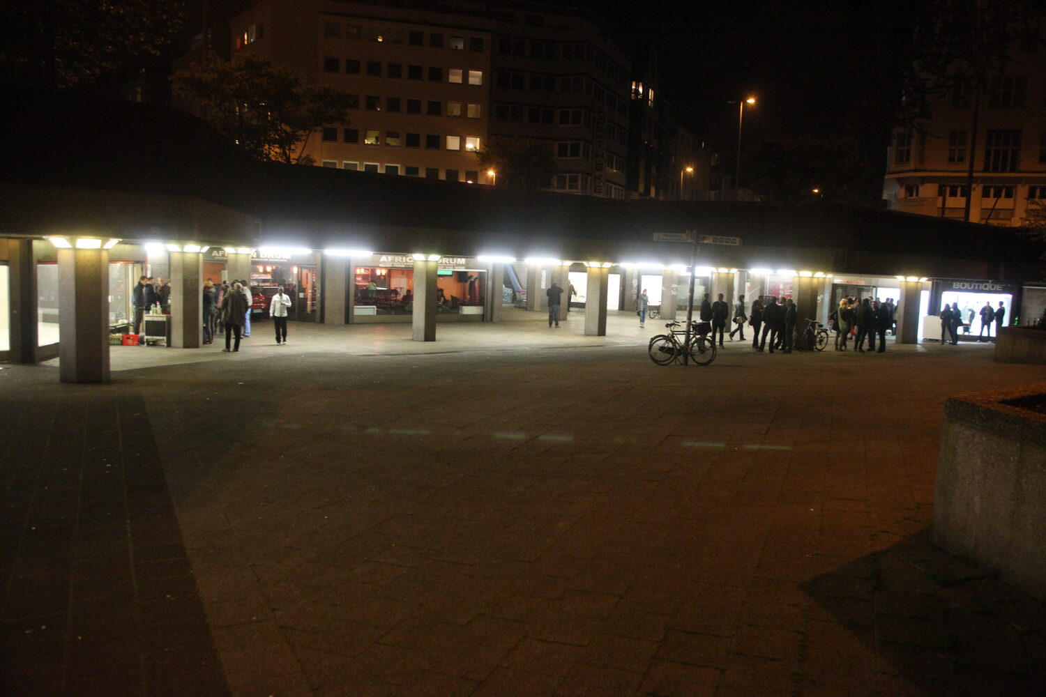 LocalNonOffline — the Ebertplatz passage at night, lit galleries along the colonnade